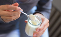 woman grabbing a spoonful of yogurt