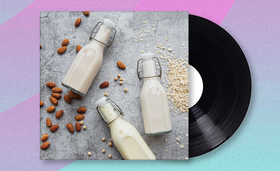 Album cover with glass bottles of dairy alternative milk, almonds and oats strewn on the table.